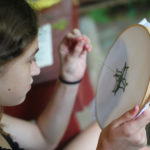 Camp girl doing needlepoint