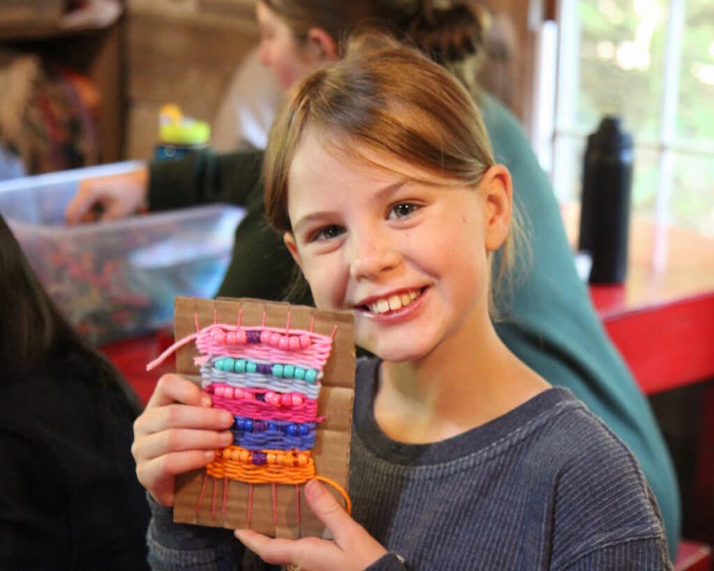 summer camp child with weaving project