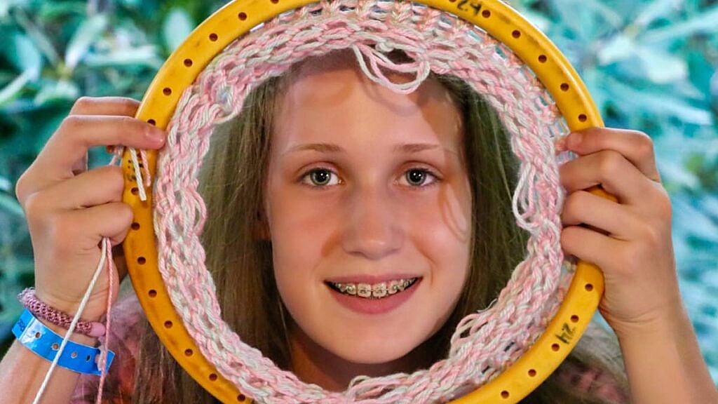girl holding knitting loom