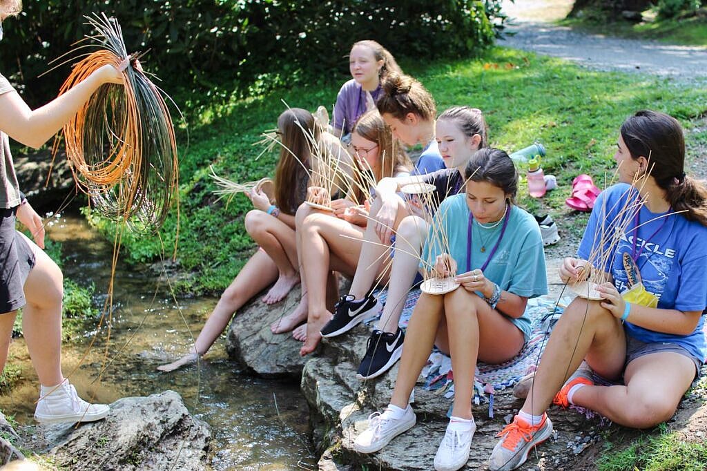 girls basket weaving near creek