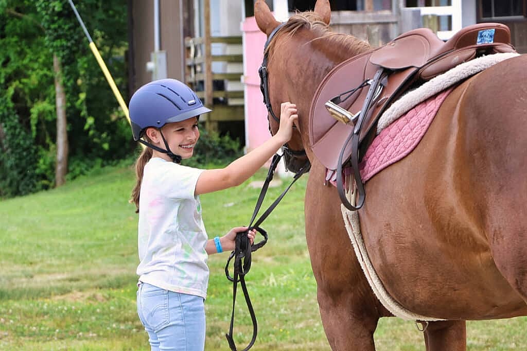 camp girl smiling with horse