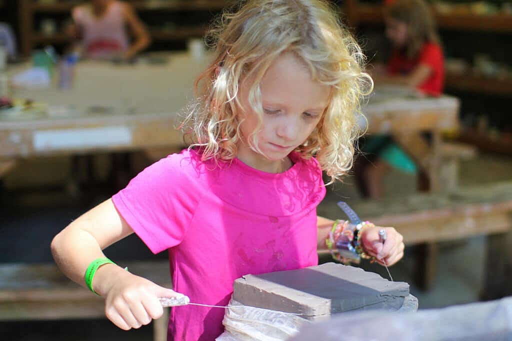child cutting clay