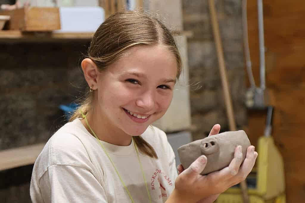 camp kid with pottery project