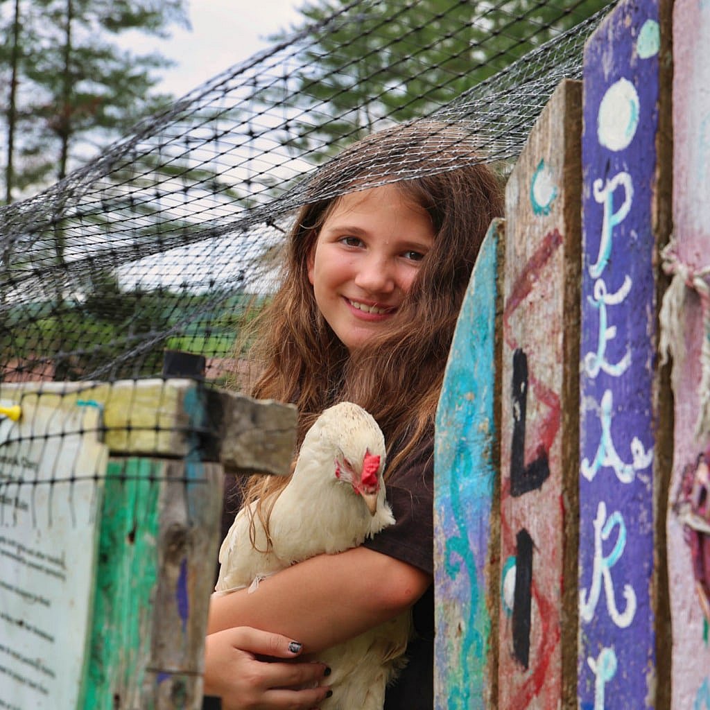 summer camp girl hugging chicken