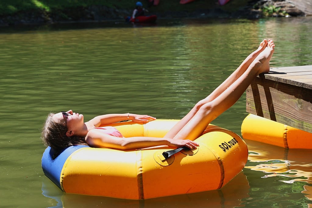 girl relaxing at camp lake