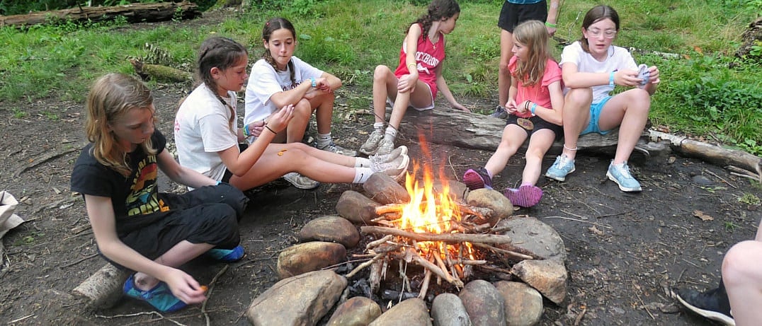 girls camping in nature with campfire