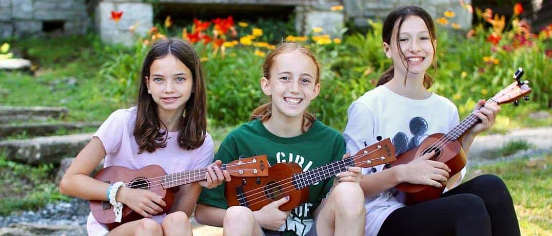 camp girls playing ukeleles