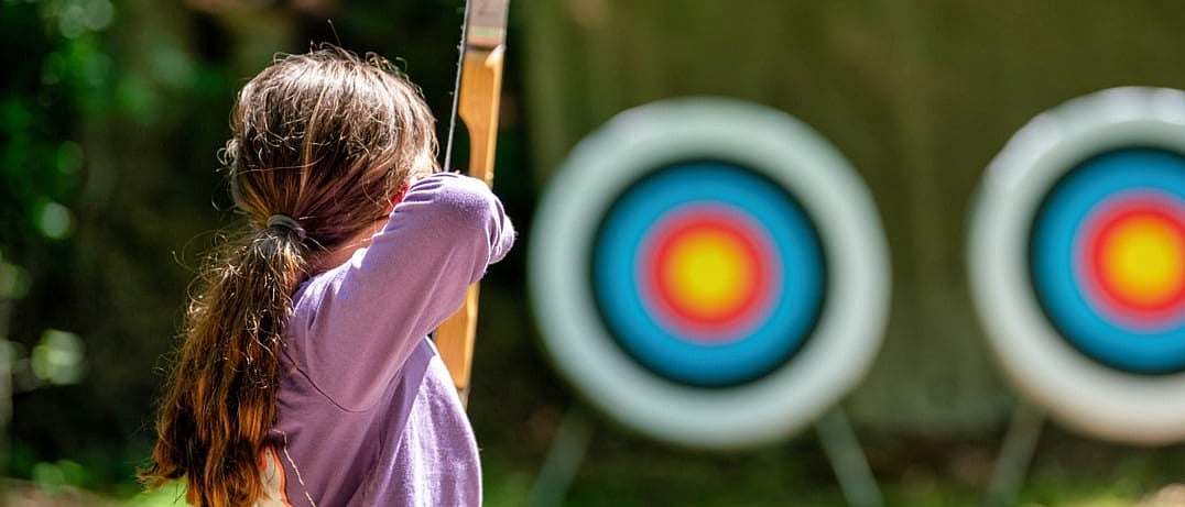camp girl aiming archery shot