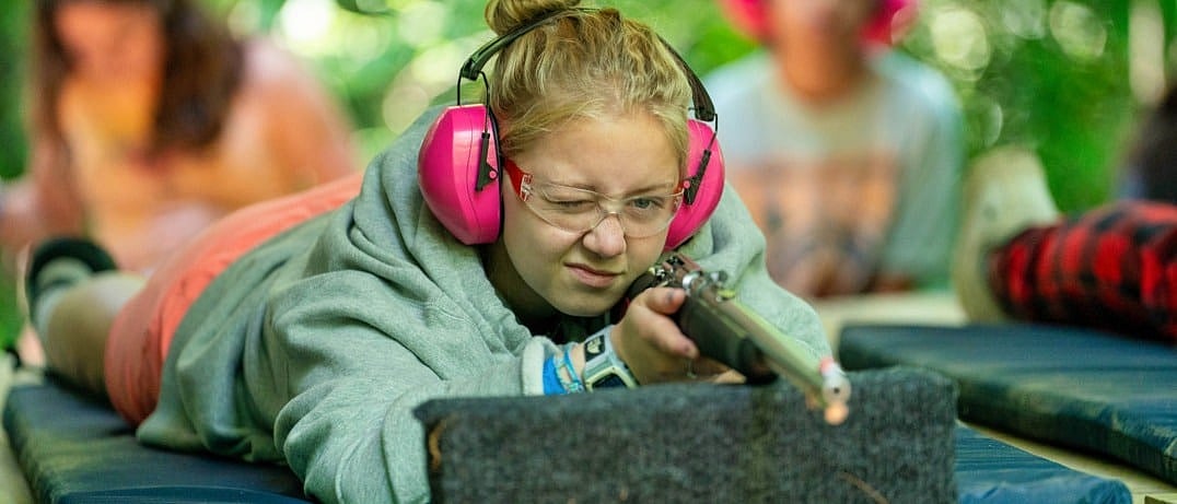 girl shooting camp rifle