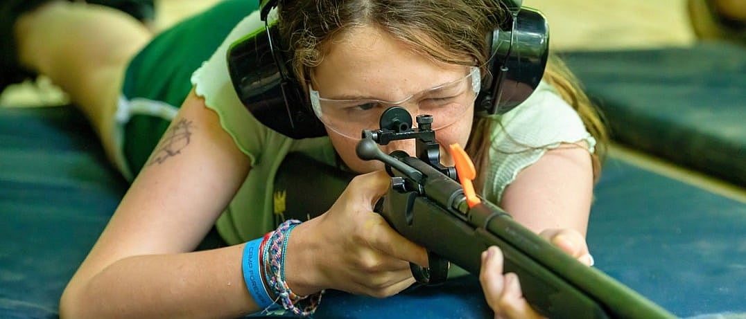 camp girl aiming a gun