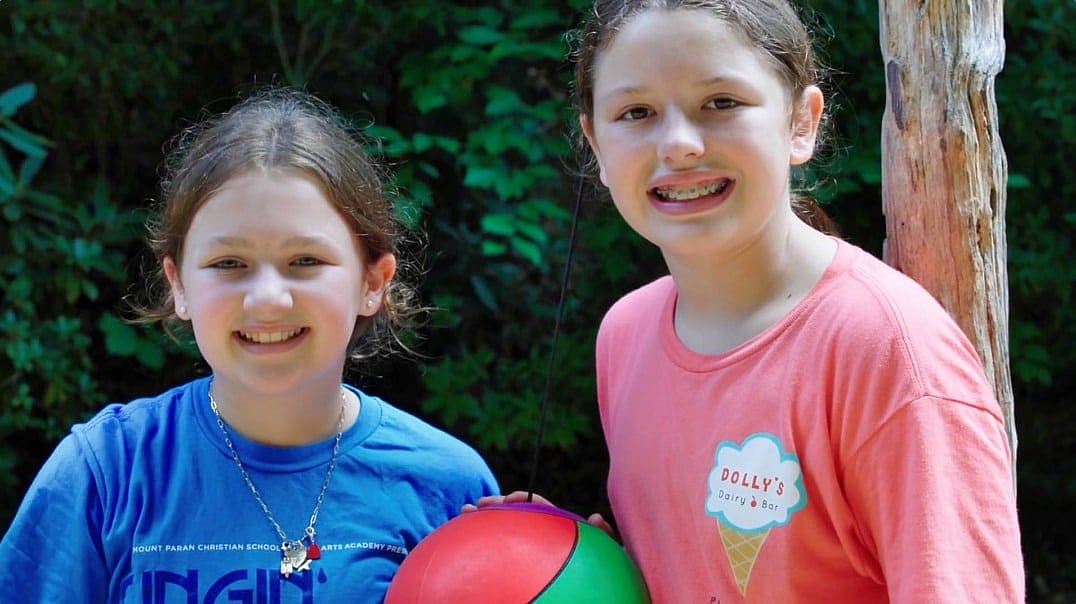 two girls at summer camp playing tetherball
