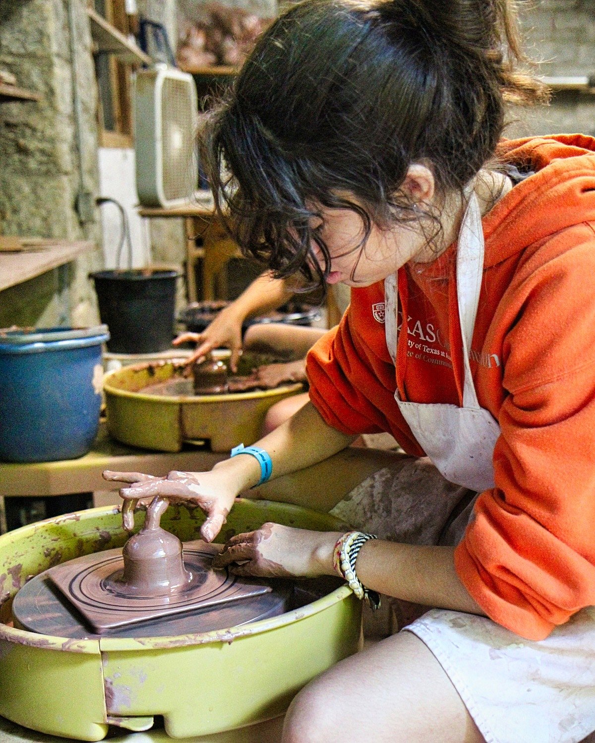 kid throwing on the potter's wheel