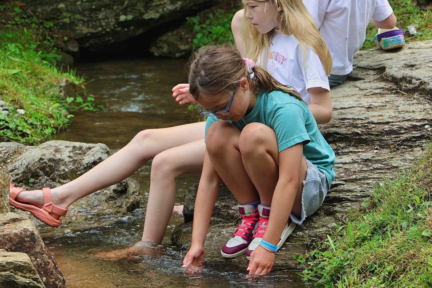 camp girls playing in a creek
