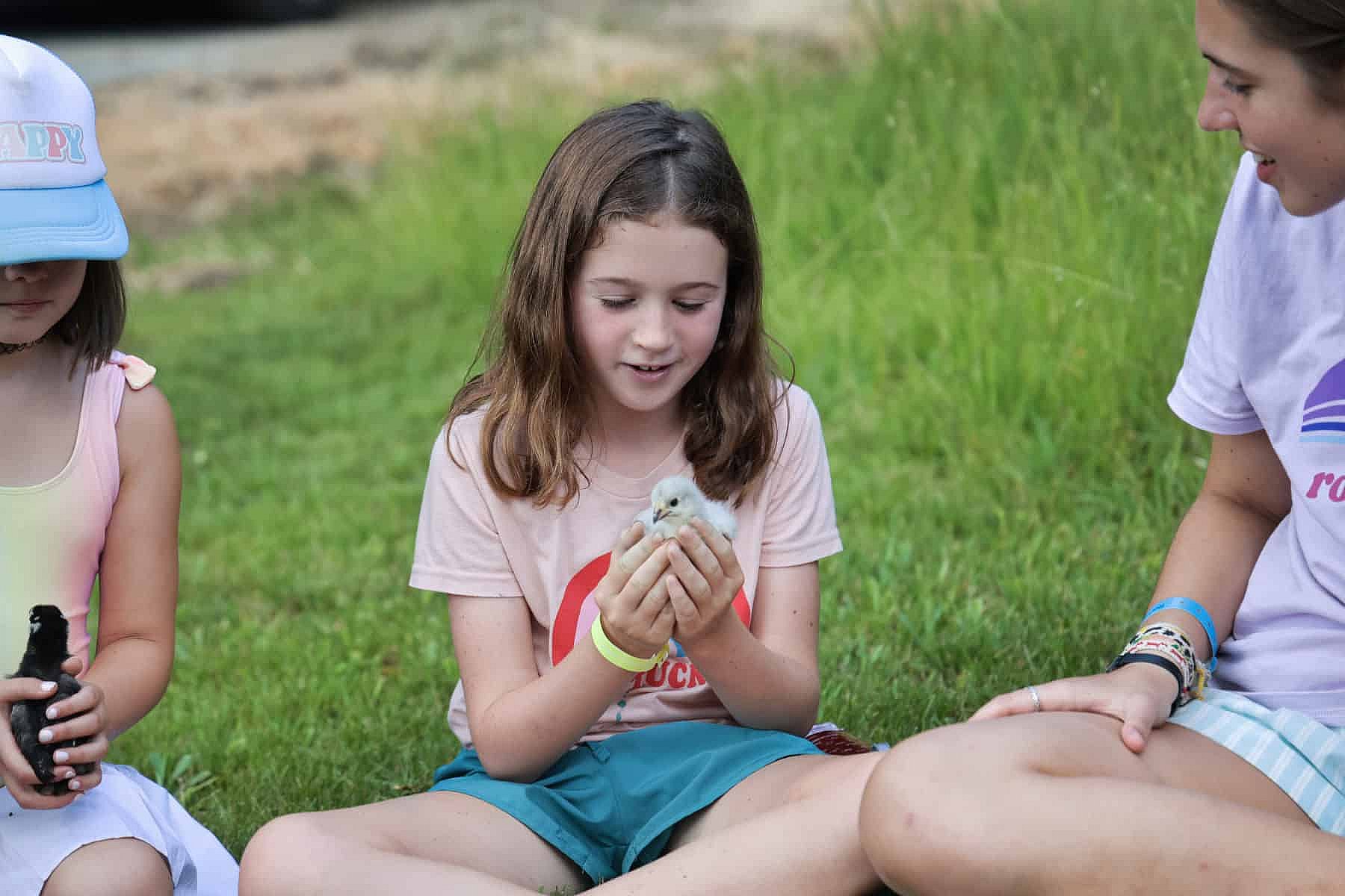 camp girl holding baby bird