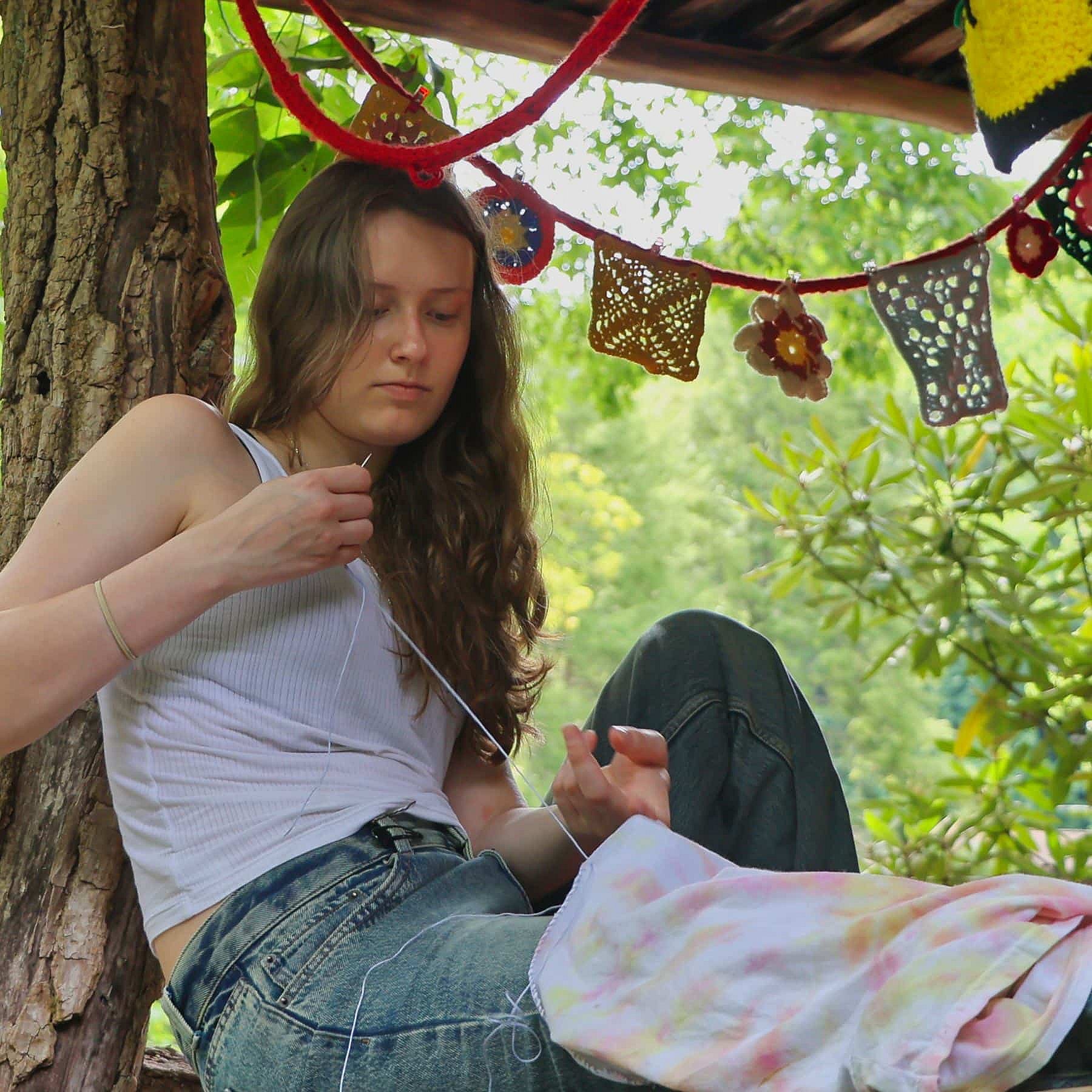 Summer camp girl with needle and thread