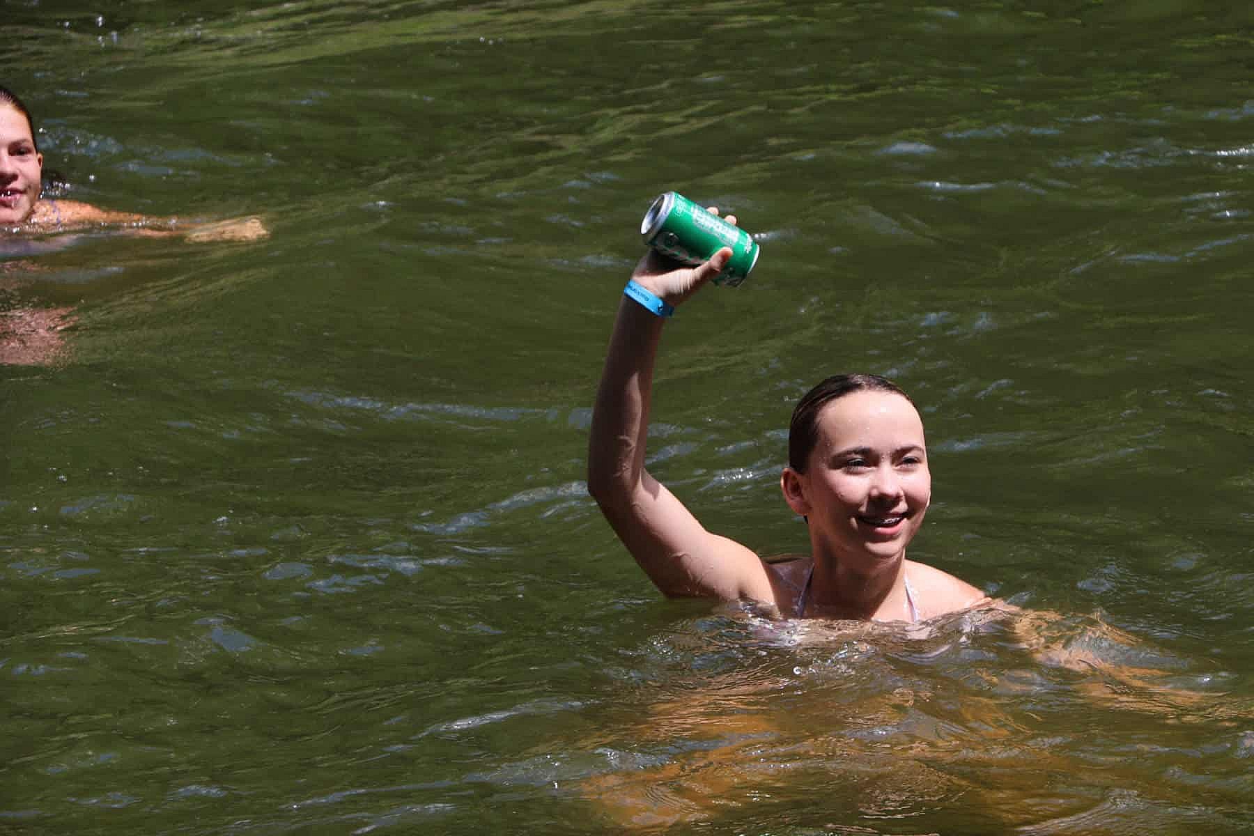 swimming girl holding soda can