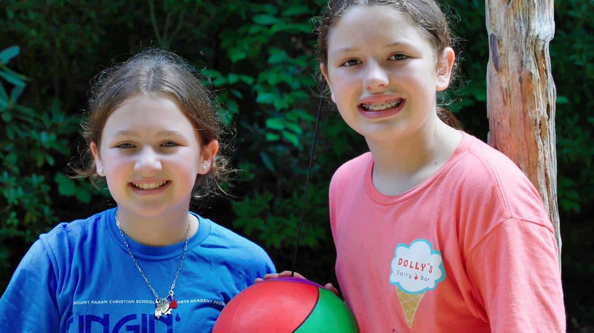 two girls at summer camp playing tetherball