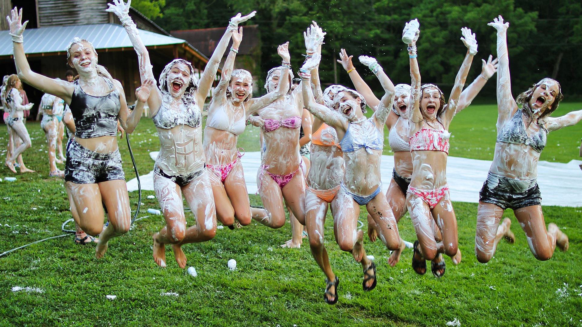 group of teen girls jumping shaving cream fight