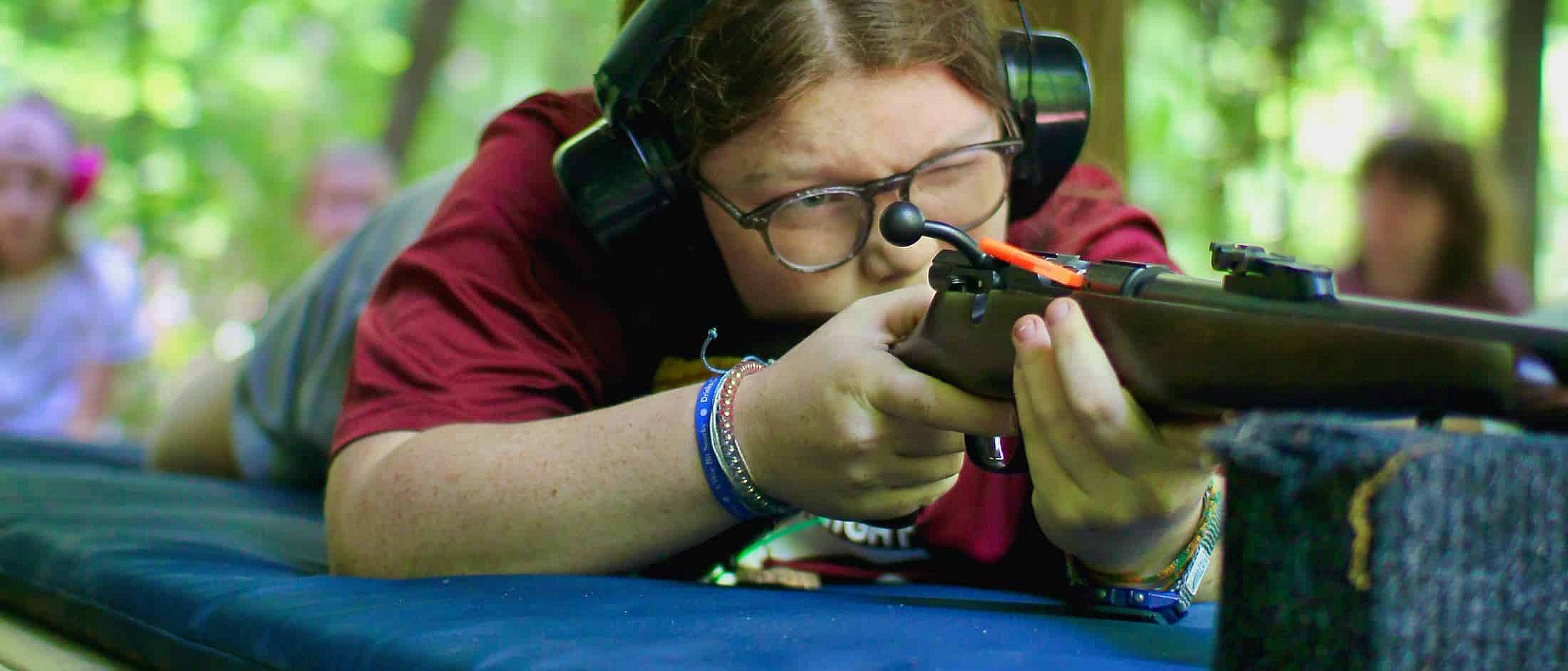summer camp girls aiming 22 rifle