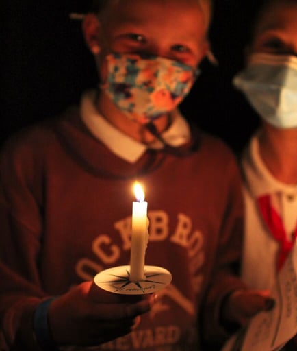 girl holding candle for closing campfire ceremony