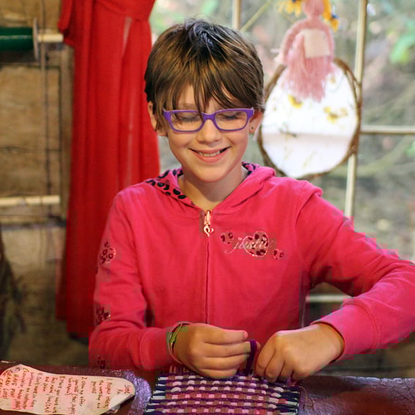 kid weaving on loom at camp