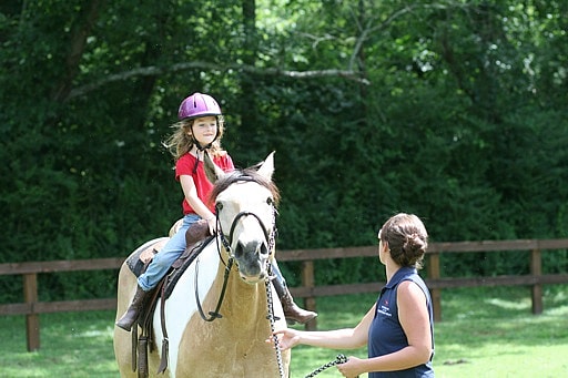 camp girl smiling on a horse
