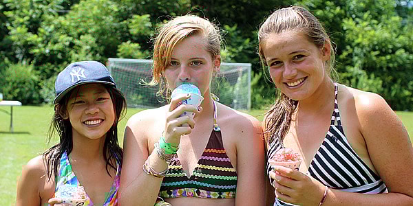 Camp girls eating snow cones in the sun