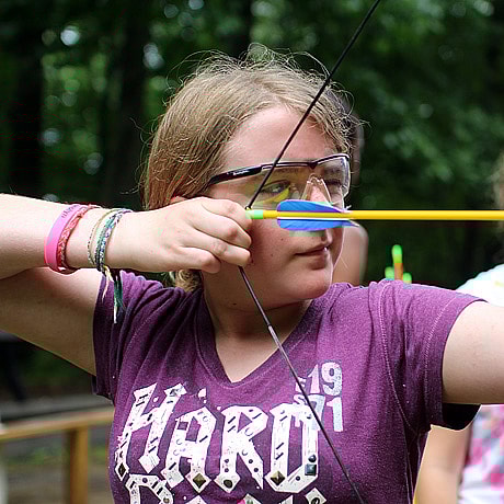 Girl archer aiming her arrow