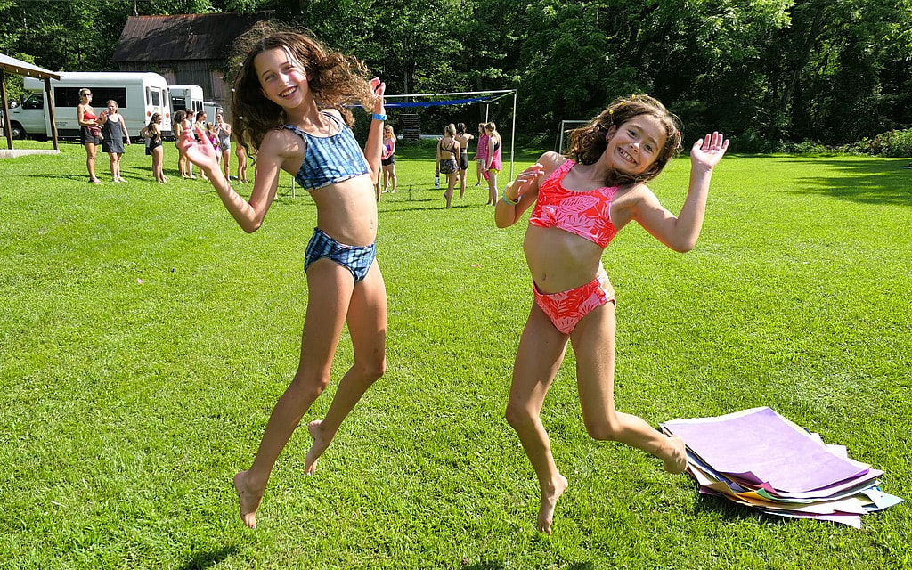 summer camp girls jumping at festival
