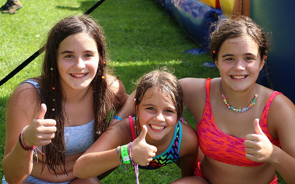 three summer camp girls giving a thumbs up