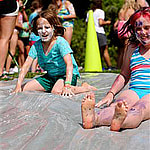 camp girls enjoying slip n slide