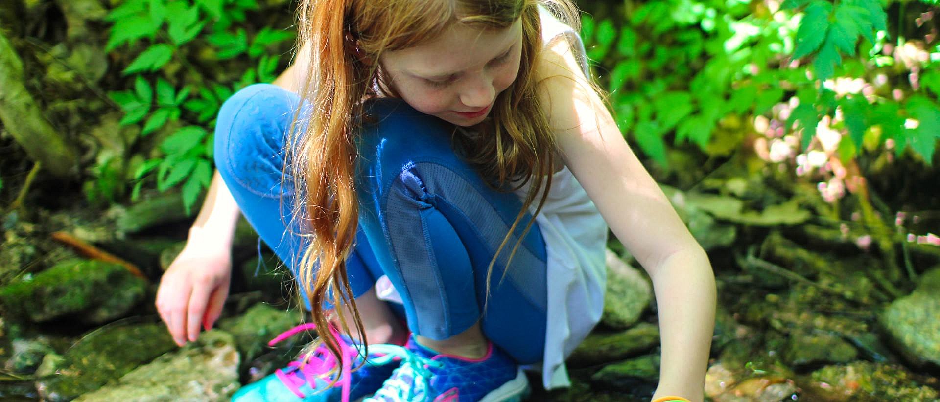 small girl exploring stream