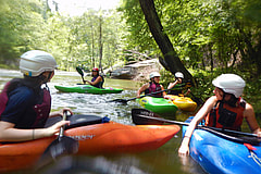 Kids at summer camp kayaking a river