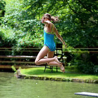 Camp girl jumping in the lake