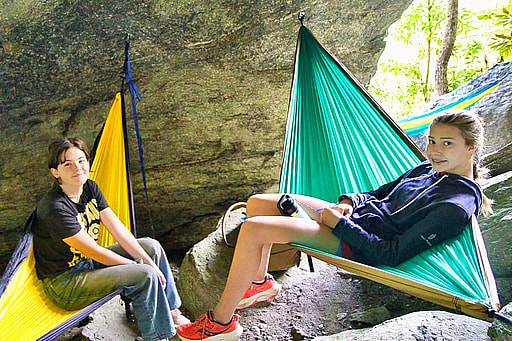 two summer camp kids in hammocks attached to rocks