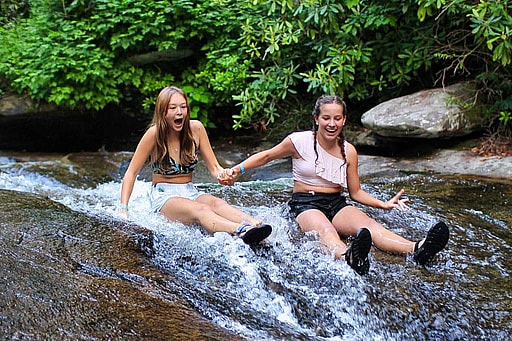 summer camp girls sliding down mountain creek