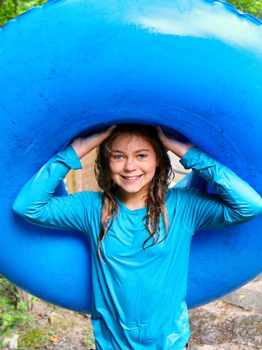 wet camp girl holding blue swim float