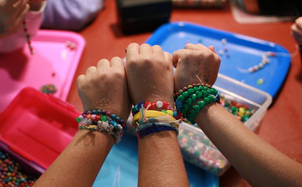 camp bracelets on three wrists