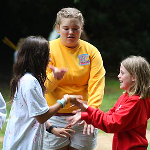 Girls playing hand game with summer camp friends