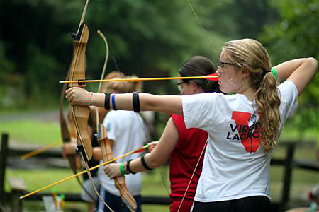 Camp kid shooting archery bow and arrow