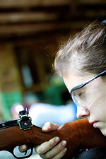 Camp girl aiming her rifle