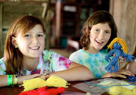 Girls making a yard doll at camp