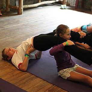 camp kids doing partner yoga pose