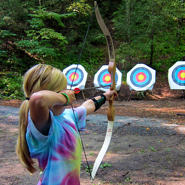 Girl shooting archery at summer camp