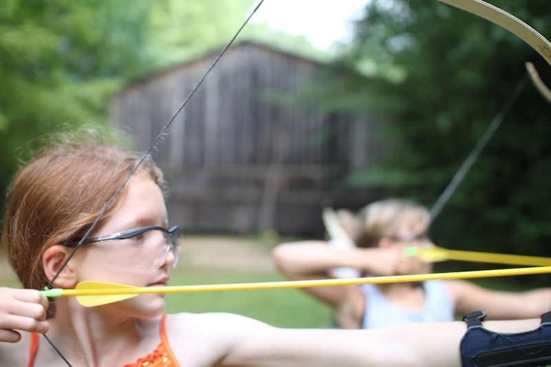 girls shooting arrow on target