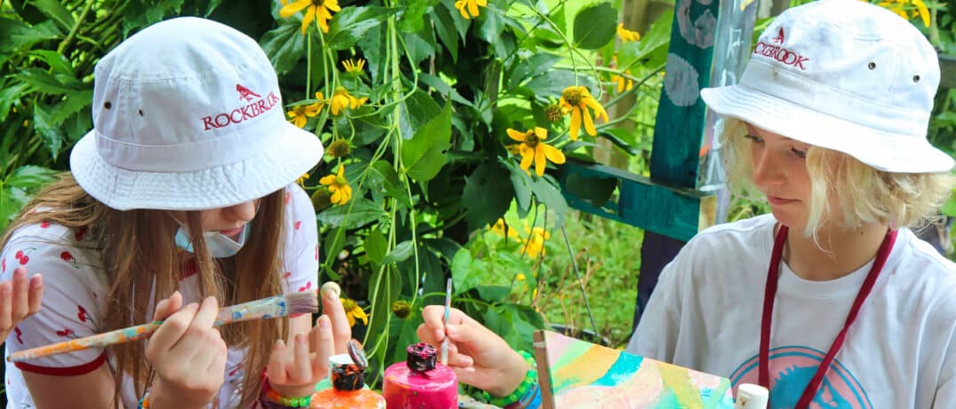 Camper painting in the field