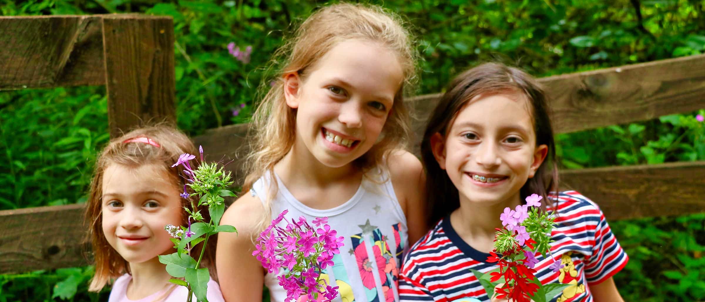 three girls enjoying the wonder of flowers