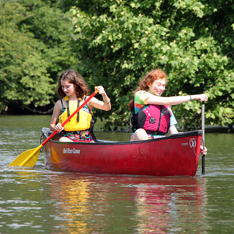 Camp Girls canoeing down a river