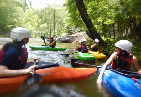 Kids at summer camp kayaking a river