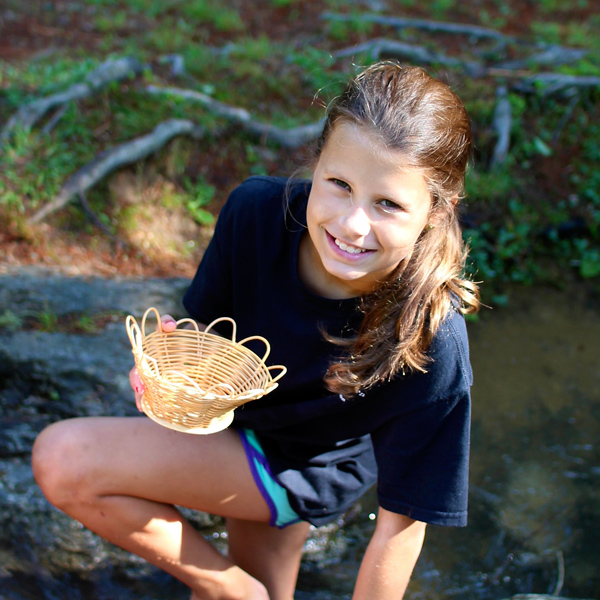 Kid By the creek making a basket